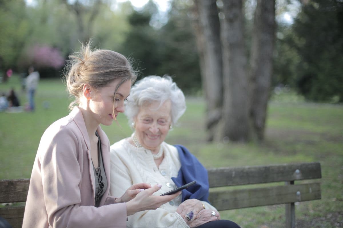Care worker helping an older woman use a tablet