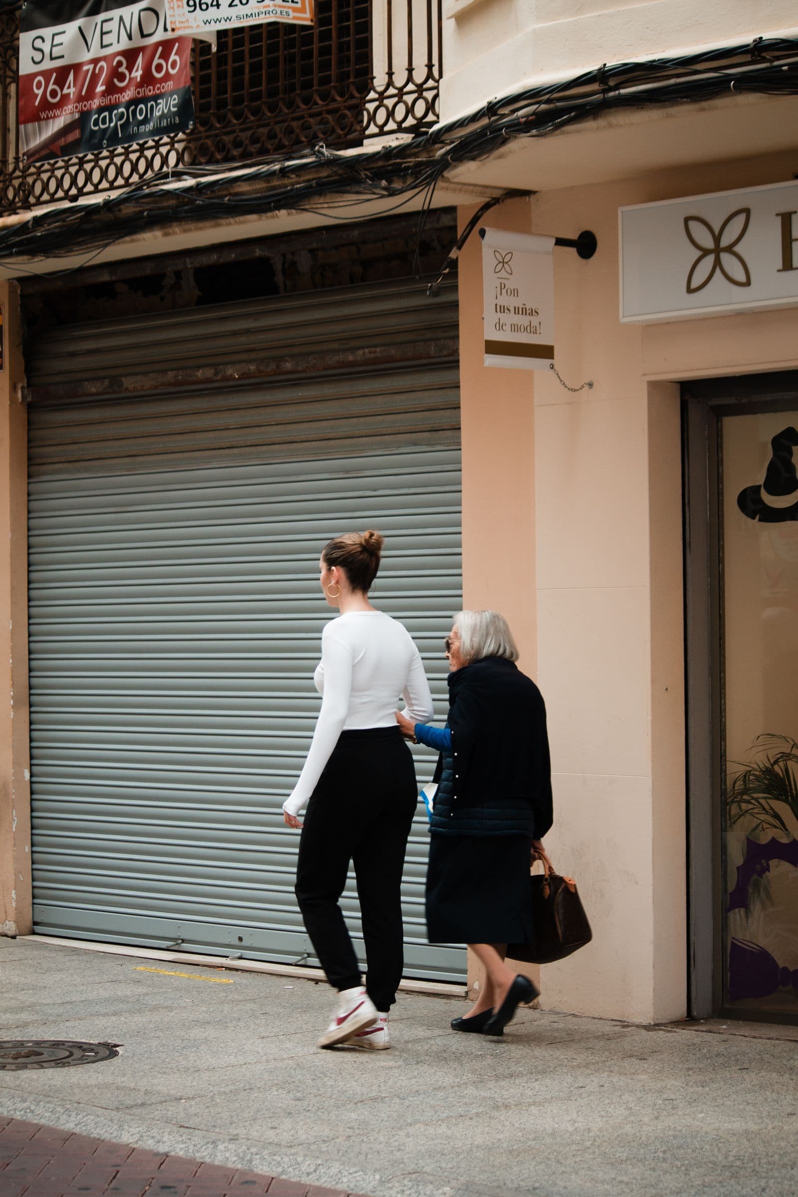 Care worker supporting an older woman during a walk